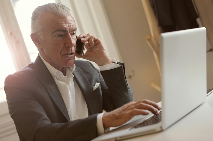 Advisor discussing M&A sell-side strategy with a client by phone