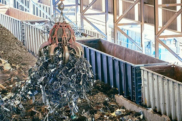 Industrial equipment handling scrap metal for recycling and waste services
